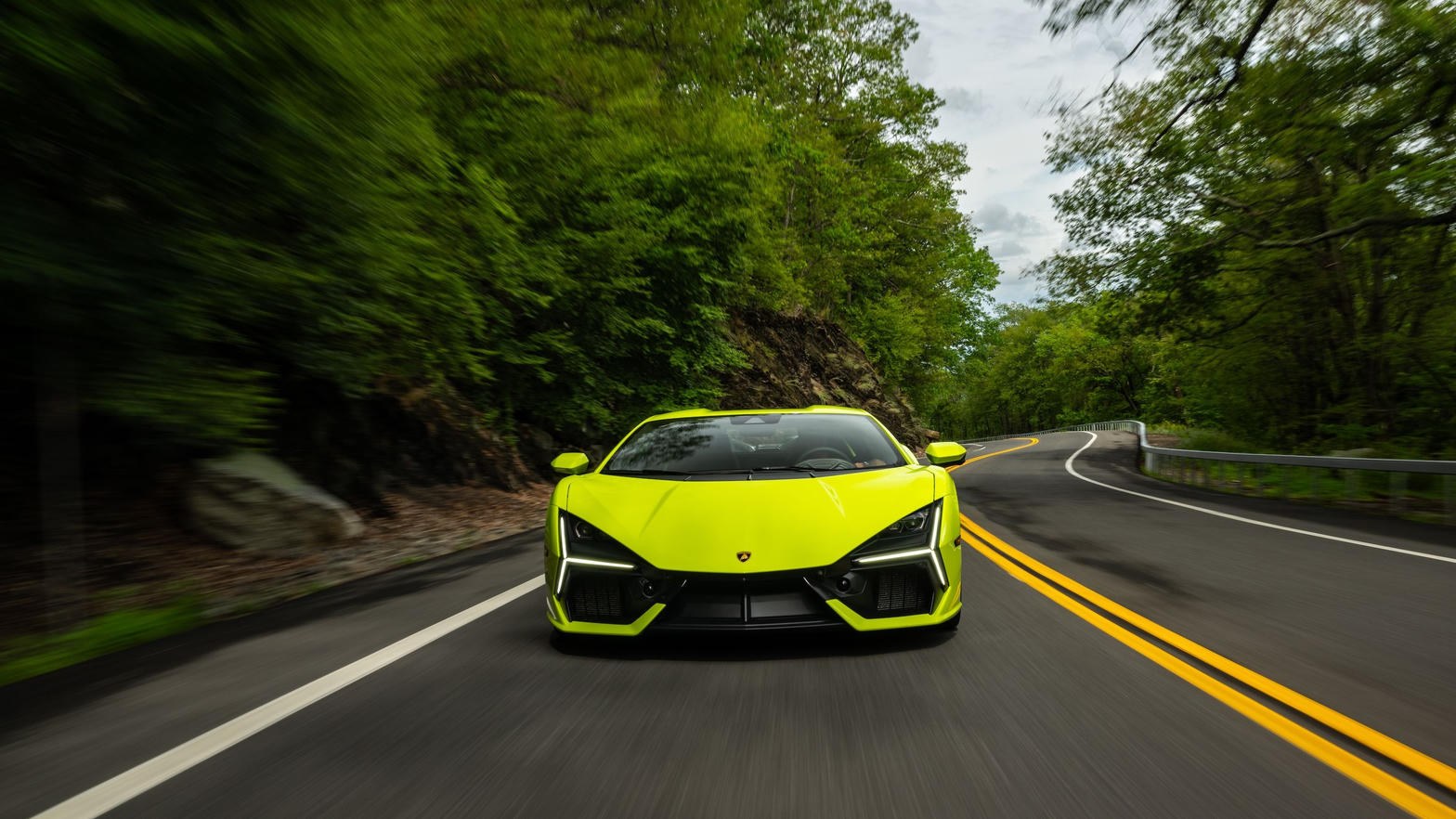 Lamborghini Revuelto on a mountain road, headlights on