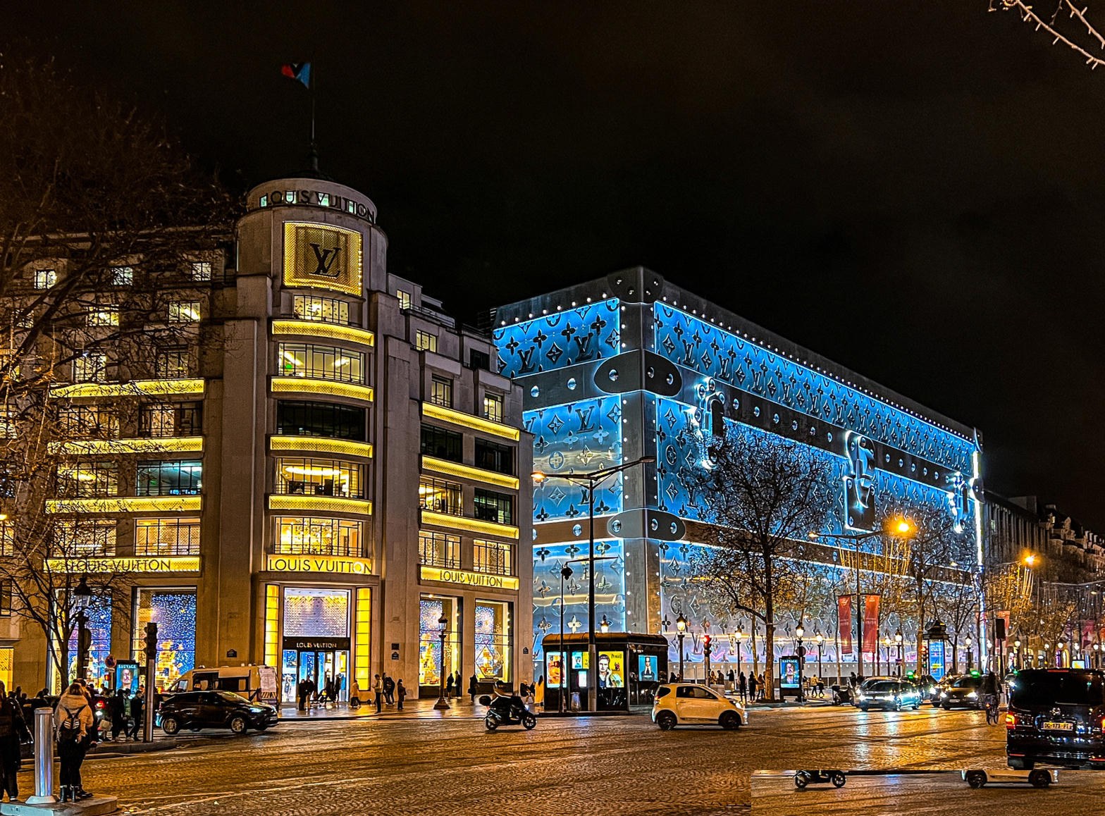 Louis Vuitton flagship on the Champs-Élysées at night — logo and trunk facade
